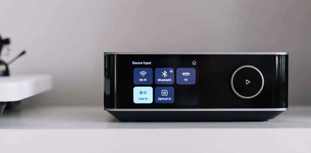 WiiM Amp Ultra Amplifier on shelf with turntable